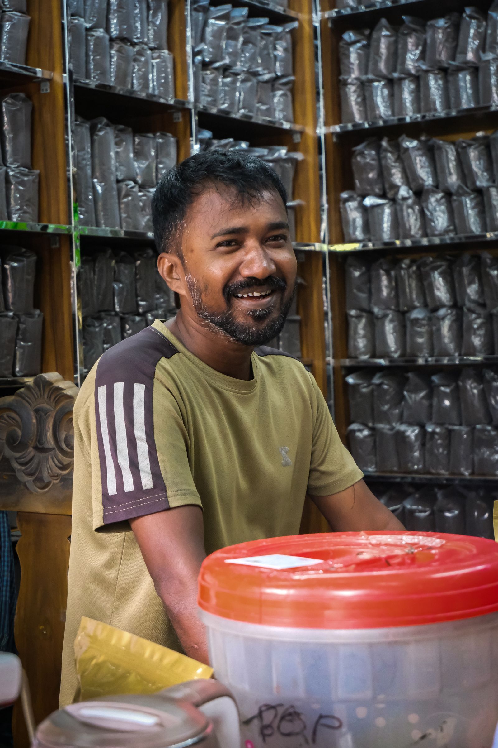 Smiling independent shop owner behind his counter